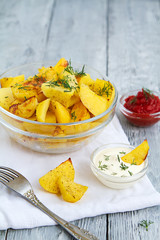 delicious fried potato slices with two sauces on wooden grey background