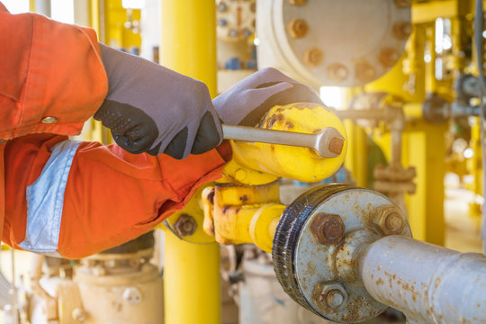 The Production Operator Adjusting Pressure Regulator Of Instrument Gas Supply System, Offshore Oil Rig Worker Operating On Control System At Oil And Gas Wellhead Remote Platform.