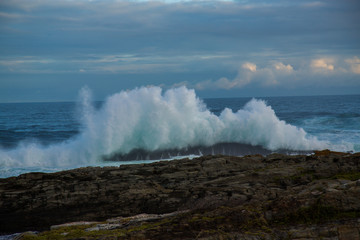 Blue waves breaking over rocks
