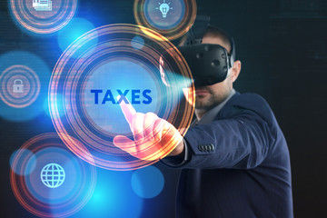 Business, Technology, Internet and network concept. Young businessman working in virtual reality glasses sees the inscription: Taxes