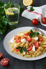 Pasta salad with cherry tomatoes and mozzarella on a plate                