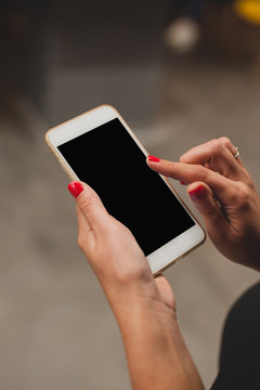 Mockup woman's hands holding black phone. Place for text or presentation website.