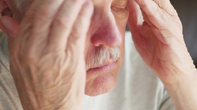 Older man enduring a headache above his eyes