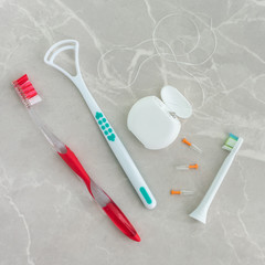 Oral hygene tools on a mrable background.