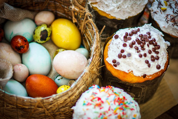 Traditional easter cake kulich Ukrainian with colored eggs in the wicker basket