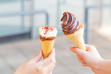 Hands holding ice cream cone on summer day