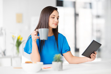 business, technology and people concept - businesswoman with tablet pc computer drinking coffee at office