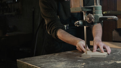 middle field on a carpenter who cuts a piece of wood with a band saw