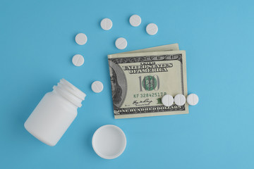 Pharmaceutical pills and bottle, hundred dollar bill. The concept of rise in price of medicines, pharmaceutical business.