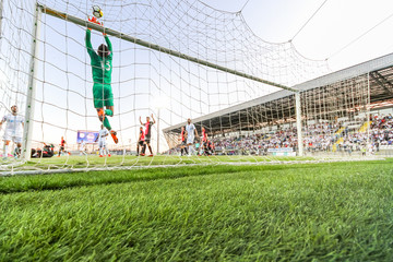 Soccer players during match. Shoot taken behind goal.