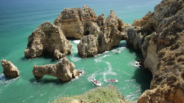 Aerial view of scenic landscape of boat trip between cliffs and natural rock formations of Ponta da Piedade in Lagos, Algarve, Portugal. Summer holidays. Tour tourism in Atlantic Ocean. Sunny day.