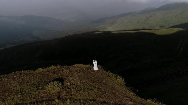 beautiful wedding couple walks in mountains aerial view 4k