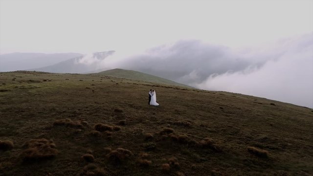 beautiful wedding couple walks in mountains aerial view 4k