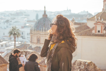 Beautiful young women looking far from the top (Castle) of a typical Spanish town (Carmona) on...