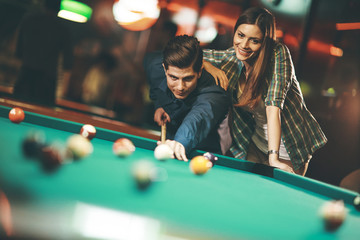Young couple playing pool