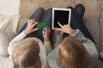 Adult woman and daughter using tablet top view