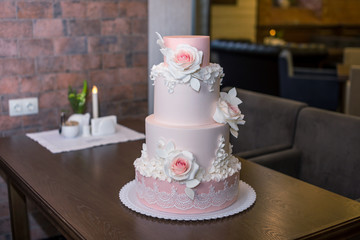 Beautiful elegant four tiered pink wedding cake decorated with roses flowers. Concept floral from sugar mastic