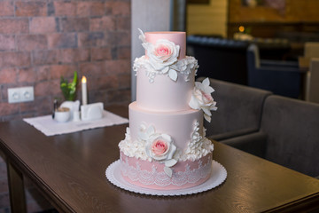 Obraz na płótnie Canvas Beautiful elegant four tiered pink wedding cake decorated with roses flowers. Concept floral from sugar mastic