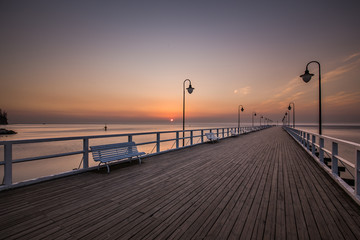 Naklejka na ściany i meble Amazing colorful sunrise over the pier in Gdynia Orlowo. Sunrise over the sea.