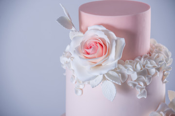 Beautiful elegant four tiered pink wedding cake decorated with roses flowers. Concept floral from sugar mastic