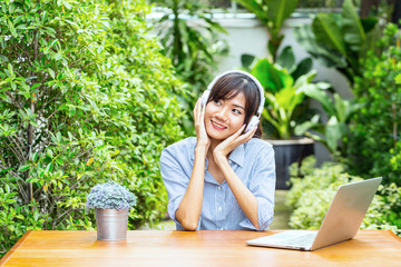 Asian young woman relaxing by listening music with laptop feeling so happiness