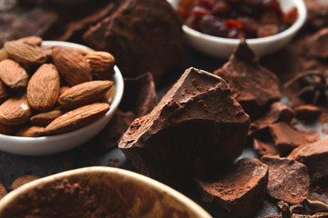 Crushed chocolate bar pieces and cocoa on gray background