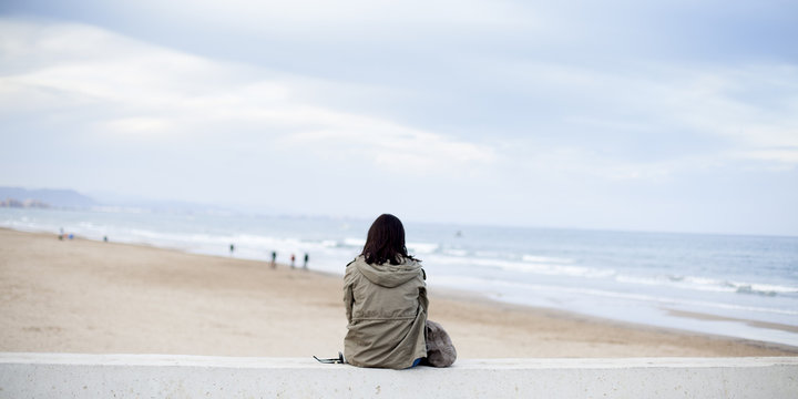 Mujer solitaria contemplando el mar
