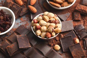 Crushed chocolate bar pieces and cocoa on gray background