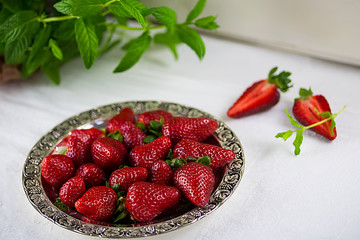Mint with strawberries on a plate, white spring