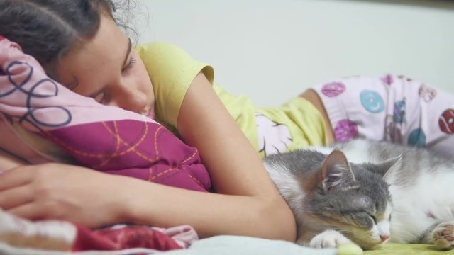 girl girl and cat sleeping on the bed and cat sleeping on the bed. teen girl cute asleep together with indoors pet cat on bed