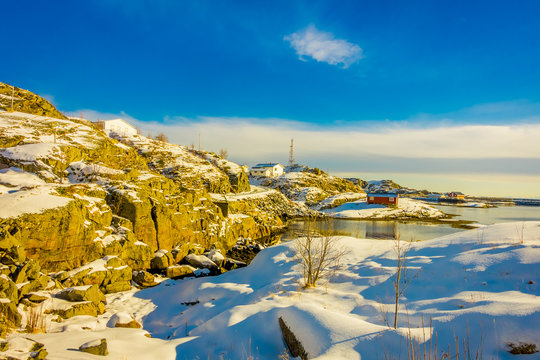 Outdoor view with some buildings in the bay in Lofoten Islands surrounded with snowy mountains and colorful winter station © Fotos 593
