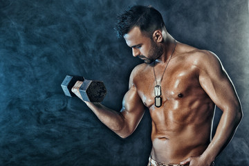 muscular man doing exercises with dumbbells