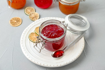 Jar and spoon with sweet jam on table