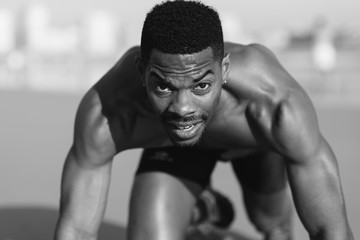Fototapeta na wymiar Running and training motivation. Black runner on beach leg power outdoor workout for improving sprint.