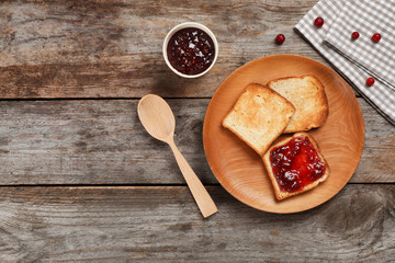 Toasts with sweet jam on wooden background, flat lay composition