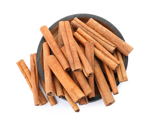 Bowl with aromatic cinnamon sticks on white background