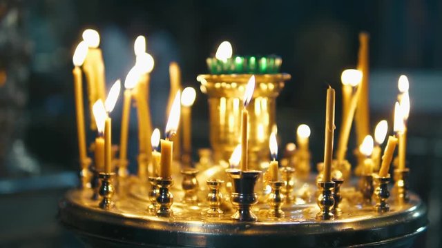 atmosphere of the Christian church, many candles burn, slow-motion shooting, smooth movement, camera slide, icons and religion, concept sacred rituals, wedding, baptism, communion, prayers to God