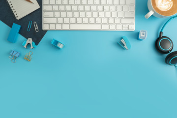 Flat lay, top view office table desk. Workspace with blank note book, keyboard, Blue office...