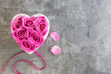 Herz aus Rosen in pink auf Hintergrund grau