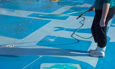 worker cleans the bottom of a large pool