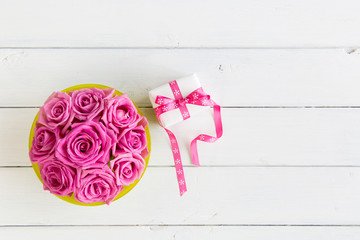 Rosenstrauss pink mit Geschenkbox auf weissem Holzuntergrund