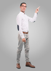 Confident young man pointing with his hand - Concept of selling with an ad - Full body shot