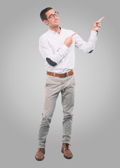 Confident young man pointing with his hand - Concept of selling with an ad - Full body shot