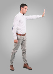 Concerned young man with a gesture of hold - Full body shot