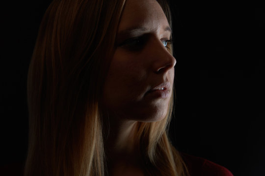 Nachdenkliche junge blonde Frau schaut zur Seite