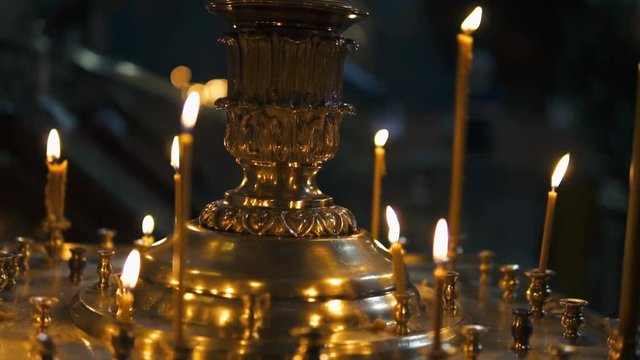 atmosphere of the Christian church, many candles burn, slow-motion shooting, smooth movement, camera slide, icons and religion, concept sacred rituals, wedding, baptism, communion, prayers to God