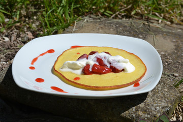 Pfannkuchen mit Erdbeeren und Sahne im Garten