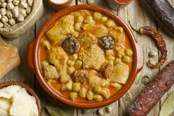 Spanish callos with chickpeas and ingredients on a wooden table