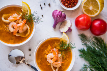 Lentil soup with seafood. Red soup with shrimps and squid top view