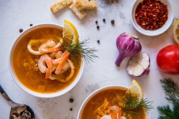 Lentil soup with seafood. Red soup with shrimps and squid top view